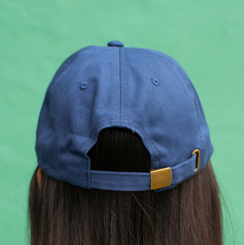 Back of navy baseball cap showing adjustable strap and buckle.