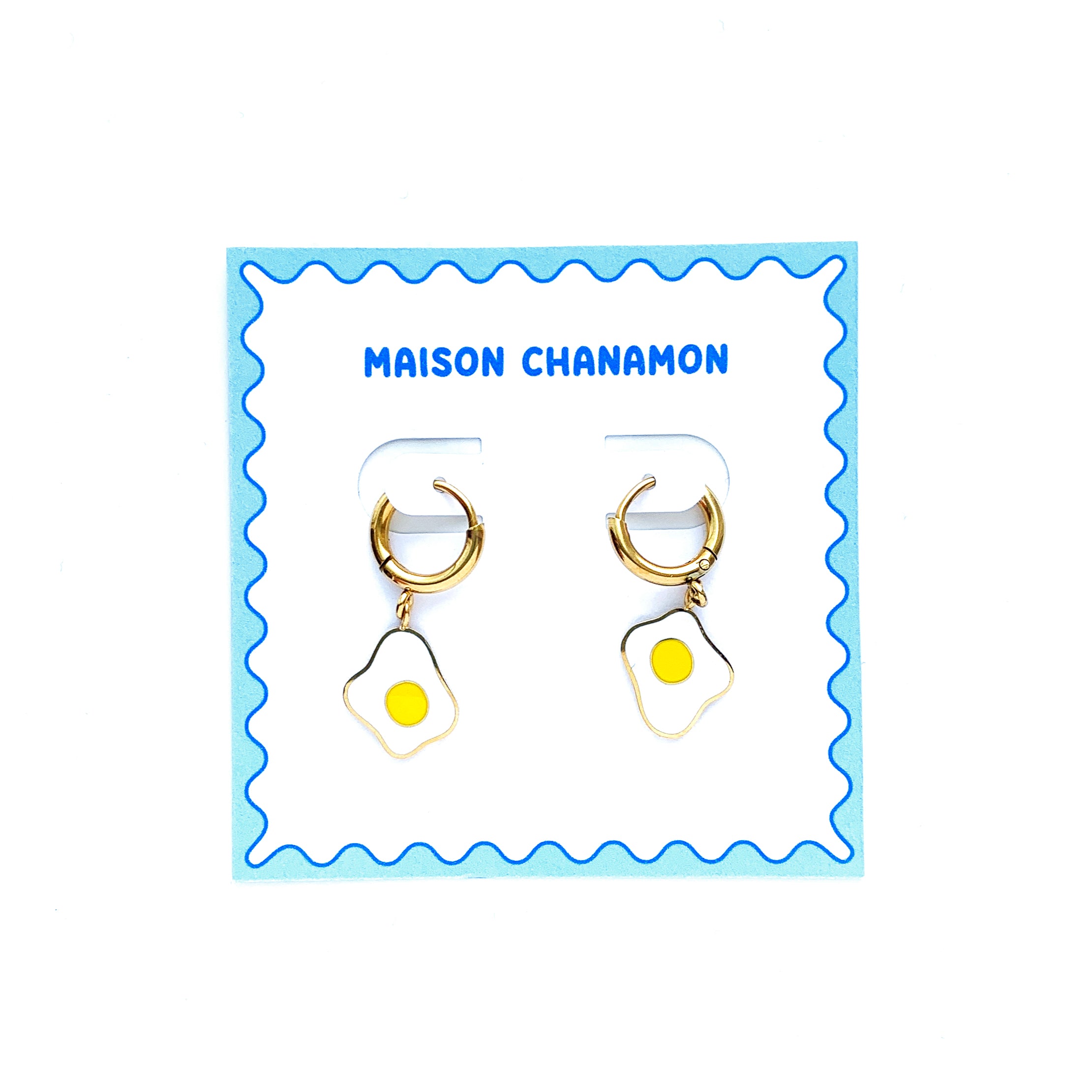 Egg enamel charms on gold huggie hoop earrings on a backing card