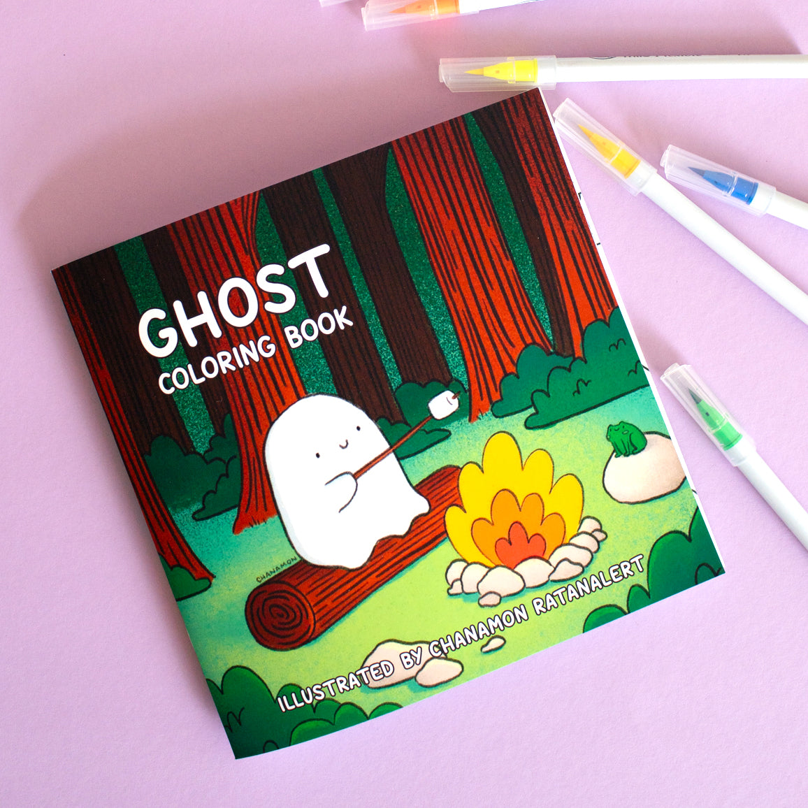 Ghost Coloring Book. Cover art: illustration of a ghost roasting a marshmallow in the woods. Illustrated by Chanamon Ratanalert
