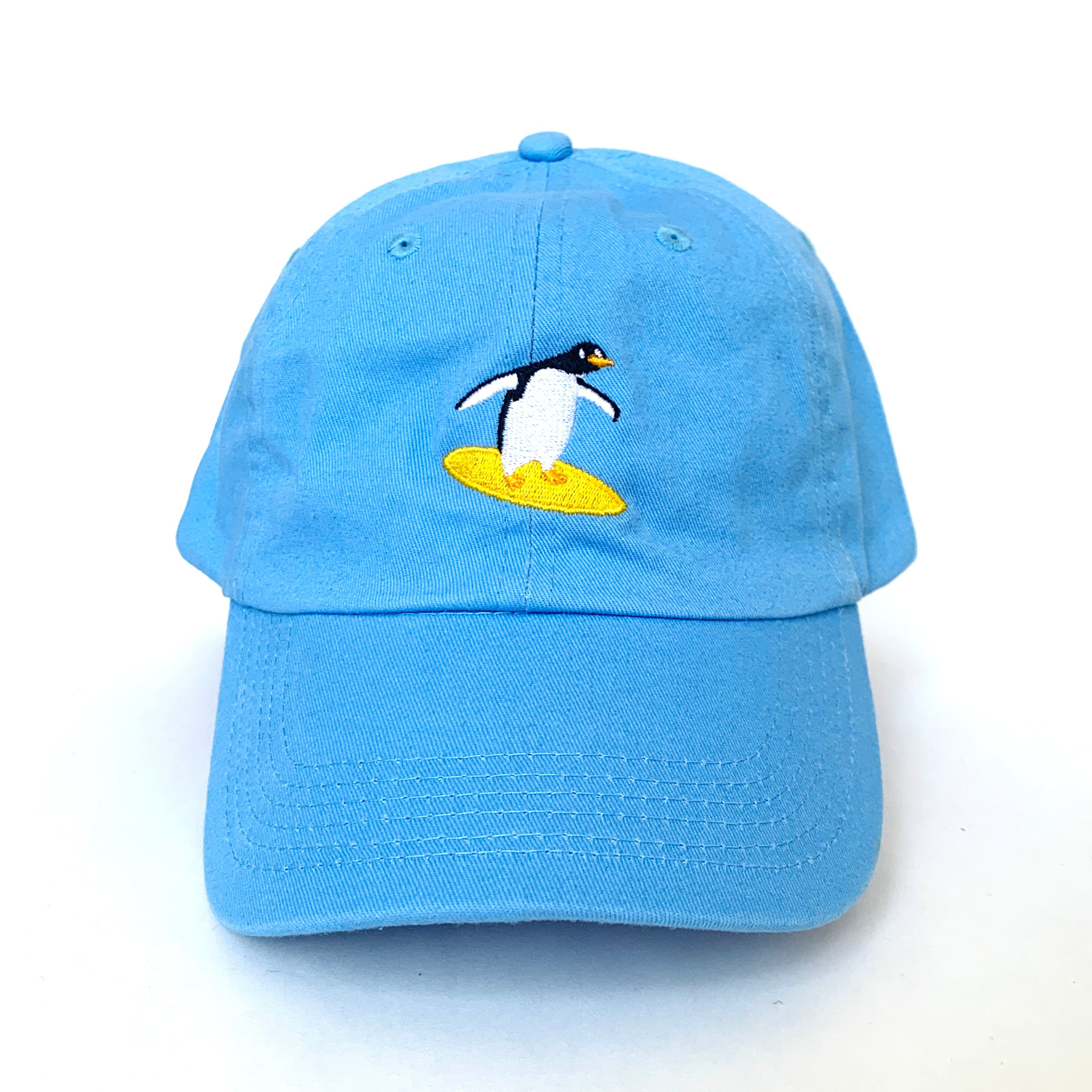 Sky blue baseball cap with a surfing penguin embroidered on the front.