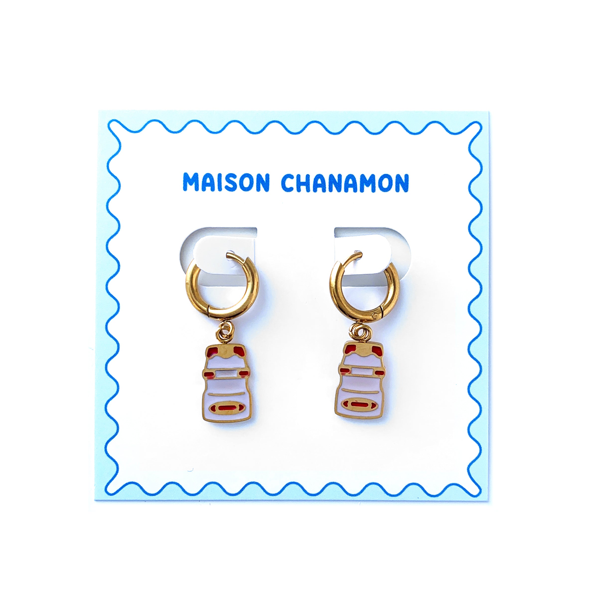 Small gold hoop earrings with charms of a yakult bottles on a backing card with blue squiggle border and "Maison Chanamon" label.