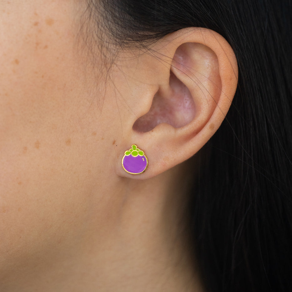 Close-up of person wearing whole mangosteen stud earring