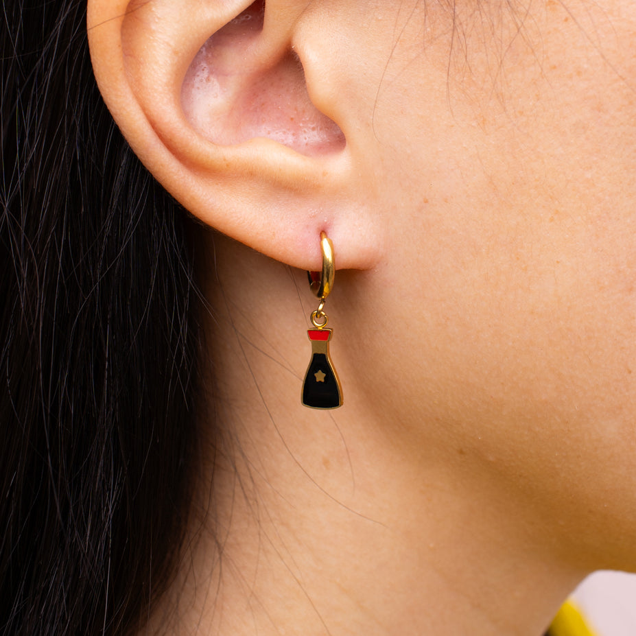 Close-up of person wearing soy sauce hoop earrings