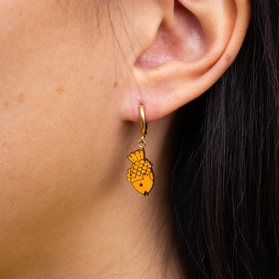 Taiyaki fish charm hanging from a gold huggie hoop, tail up