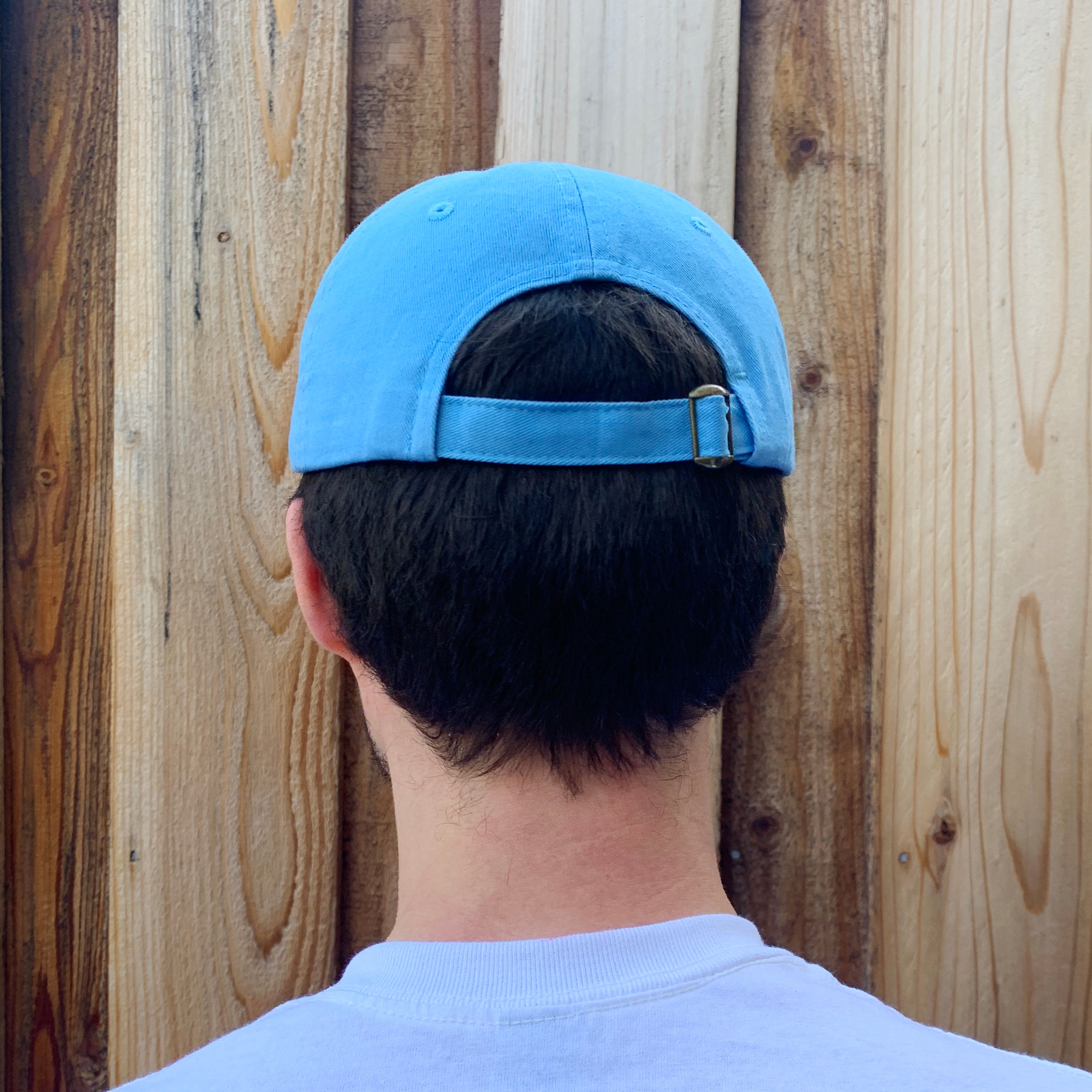 Back view of sky blue baseball cap with adjustable buckle strap.