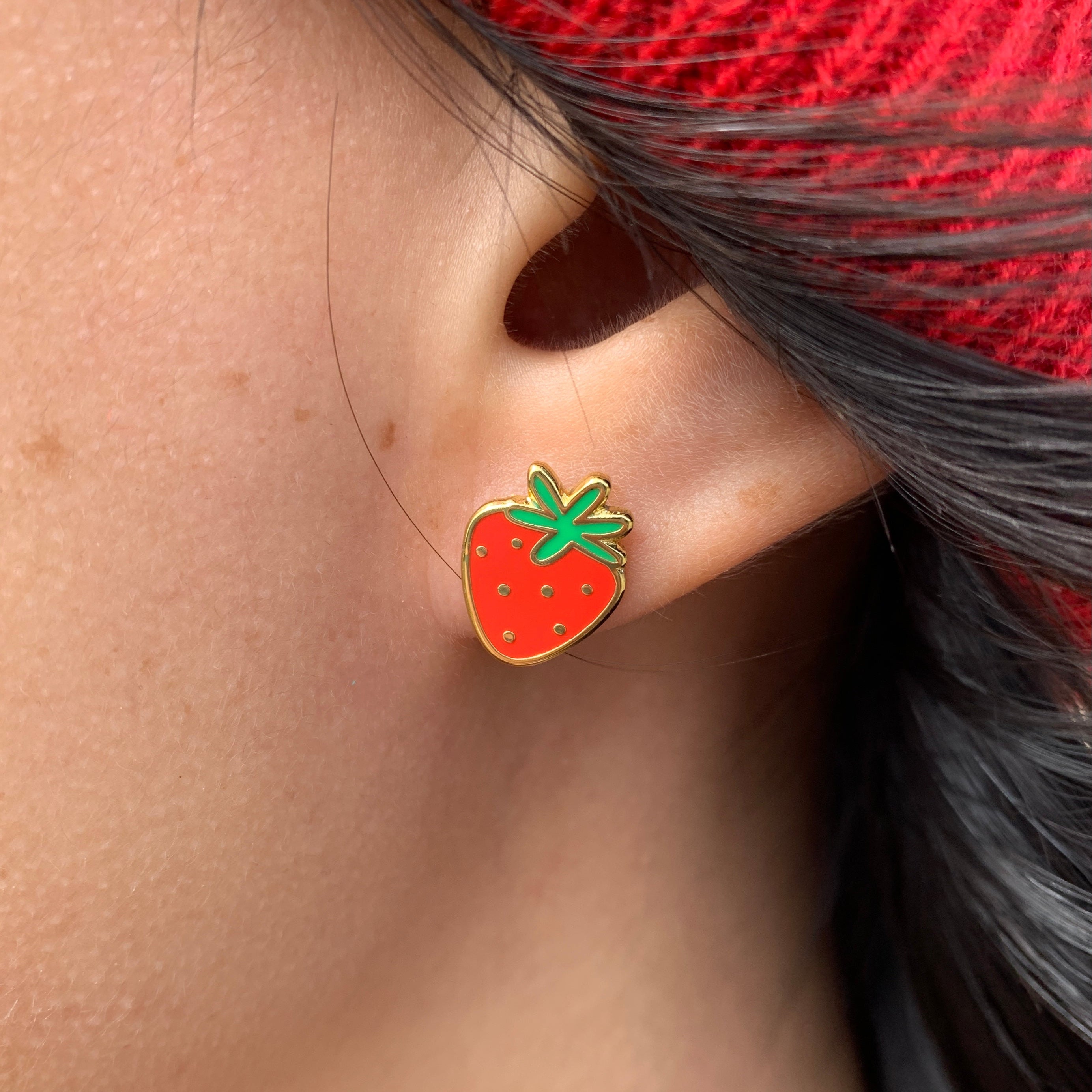 close-up of ear with strawberry stud earring